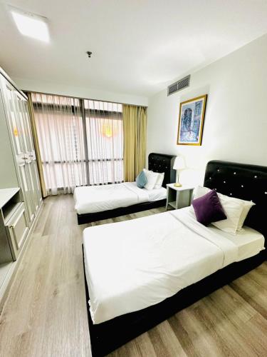 a hotel room with two beds and a couch at The Times Square By Family Suites in Kuala Lumpur