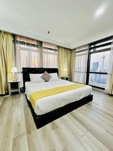 a large bedroom with a large bed with yellow sheets at The Times Square By Family Suites in Kuala Lumpur