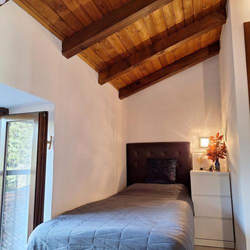 a bedroom with a bed with a wooden ceiling at Villa Viva-Como in Domaso