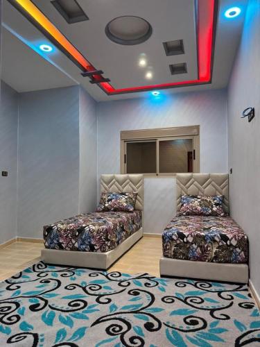 two beds sitting in a room with a rug at apartment for guests in Demnat