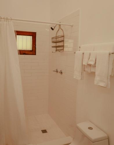 a white bathroom with a shower and a toilet at Maison Rouge -Room 1 in Christiansted
