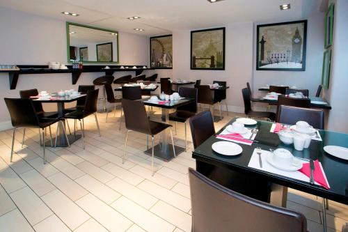ein Speisesaal mit Tischen und Stühlen in einem Restaurant in der Unterkunft Bloomsbury Palace Hotel in London