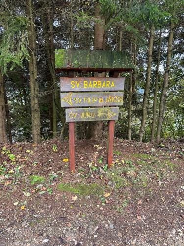 a street sign in the middle of a forest at Apartments Barbra - Robinson life in Slovenj Gradec