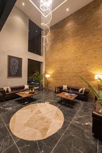 a lobby with couches and tables and a chandelier at The Farms Club in Islamabad