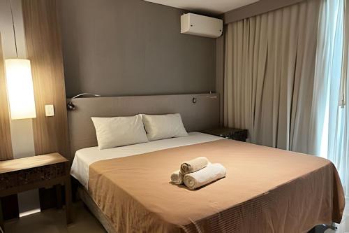 a hotel room with a bed with two towels on it at Brisas do Lago - Apartamento 2 in Brasilia
