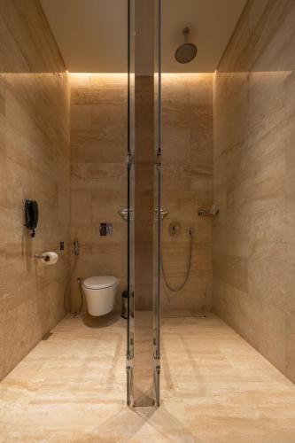 a bathroom with a glass shower with a toilet at SHIRVAN Hotel City Yard Jeddah in Jeddah