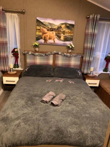 a bedroom with a bed with two slippers on it at Woodland Lodge in Plumbland