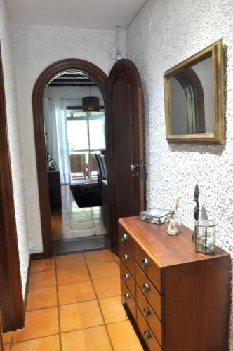 a room with a wooden dresser and a mirror at Refúgio Guest House in São Vicente