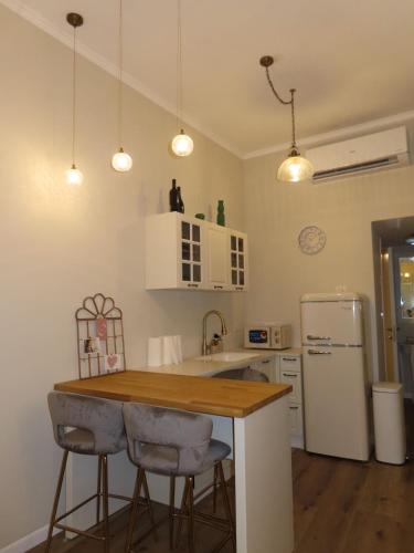 a kitchen with a table and two bar stools at קאסה לונה בוטיק CASA LUNA boutique in Gan Yavneh