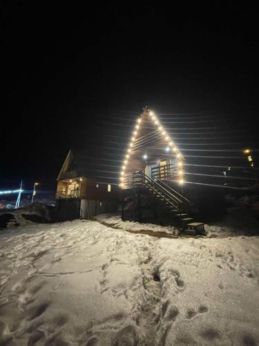 a building with lights on the side of it in the snow at Chalet Gudauri in Gudauri