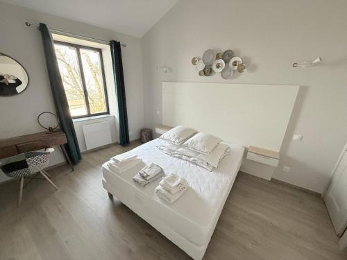a bedroom with a white bed and a window at Gîte du Château de Treffort in Treffort