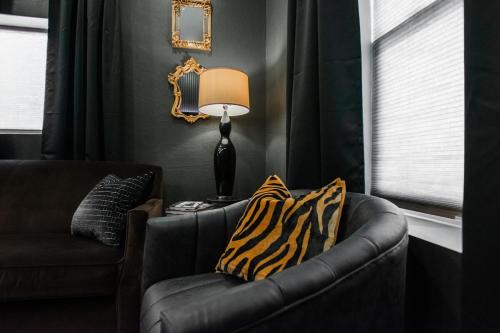 a black living room with a couch and a lamp at Speakeasy Suite at ArnoTriplex! in Albuquerque