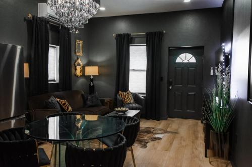 a living room with black walls and a glass table at Speakeasy Suite at ArnoTriplex! in Albuquerque