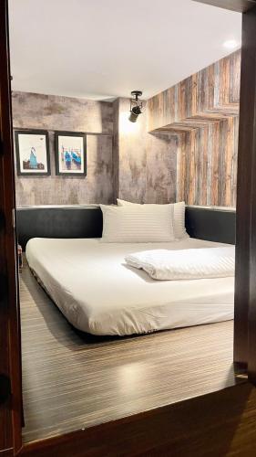 a bedroom with two beds with white sheets at The First 南灣膠囊旅店 in Nanwan