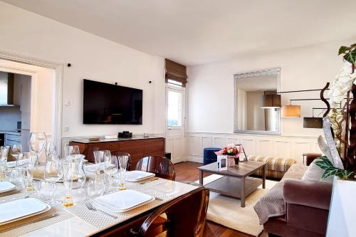 Una sala de estar con una mesa y un televisor. en Le Terranova - Maison hypercentre, en Deauville