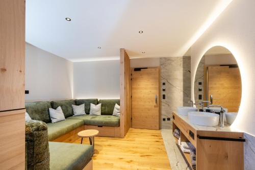 salon z kanapą i umywalką w obiekcie Hotel Lindnerhof w mieście San Lorenzo di Sebato
