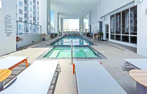 a large swimming pool in a large building at Sky-High oasis Large Studio POOL & GYM in Miami