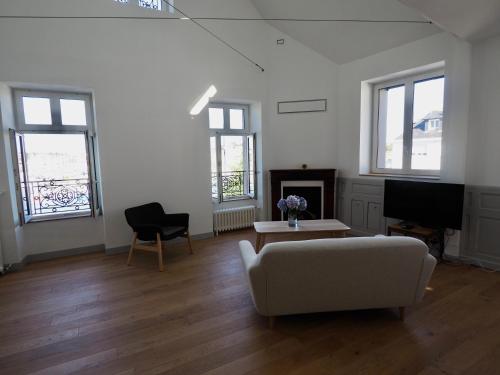 un salon avec un canapé, une table et une télévision dans l'établissement Maison Le Rose, à Concarneau