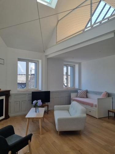 - un salon avec une lucarne, un canapé et une chaise dans l'établissement Maison Le Rose, à Concarneau