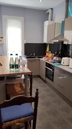 une cuisine avec un comptoir et une table à l'intérieur dans l'établissement Maison calme avec jardin, proche des transports, à Nice