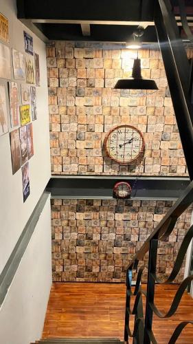 a staircase with a brick wall with a clock on it at The First 南灣膠囊旅店 in Nanwan