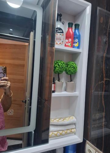a refrigerator door open with towels and plants in it at Azur appartement essaouira in Essaouira