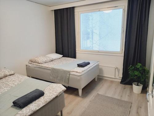 a bedroom with two beds and a window at Apartment Little Mermaid, Pieni Merenneito in Rauma