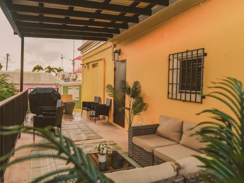 a patio with a couch on a balcony at Maison Rouge - Room 3 in Christiansted