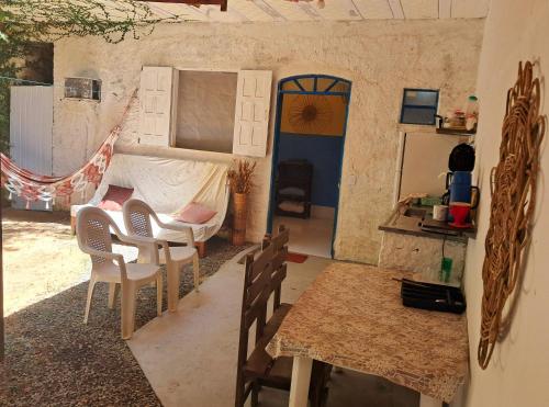 a room with a bed and a table and chairs at Casinha Guiné MorroSP in Morro de São Paulo