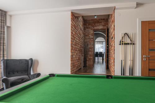 a living room with a pool table and a chair at Dream Holiday z Sauna i jacuzzi Lovely Krynica Zdrój in Florynka