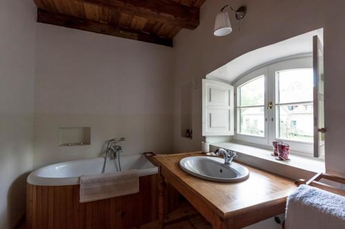 a bathroom with a tub and a sink and a window at The Bat Barn in Kelevíz
