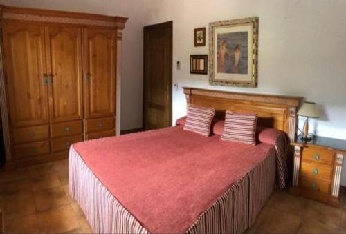 a bedroom with a large bed with a red blanket at Naturaleza-confort in Arroyo Frio