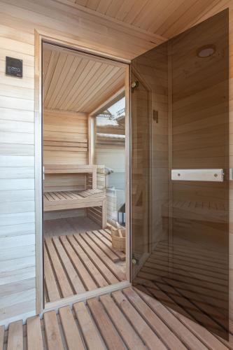 a sauna with a glass door on a wooden deck at Dream Holiday z Sauna i jacuzzi Lovely Krynica Zdrój in Florynka