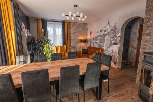 a dining room with a wooden table and chairs at Dream Holiday z Sauna i jacuzzi Lovely Krynica Zdrój in Florynka