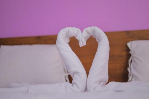 a pair of white socks forming a heart on a bed at The dream gir farm in Junagadh