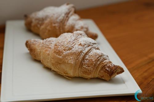 two croissants on a white plate on a table at B&B Marina House Porto Ercole in Porto Ercole