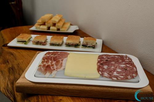 two plates of food on a table with cheese and meats at B&B Marina House Porto Ercole in Porto Ercole