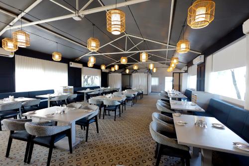 a dining room with tables and chairs and lights at The Fern Seaside Luxurious Tent Resort Daman in Daman