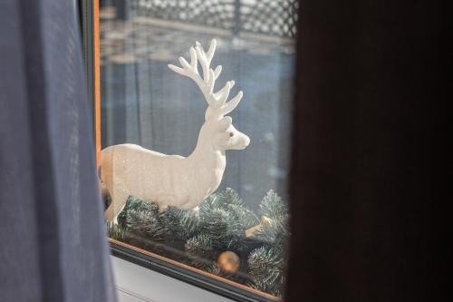 a reindeer sitting in a window with christmas decorations at Dream Holiday z Sauna i jacuzzi Lovely Krynica Zdrój in Florynka