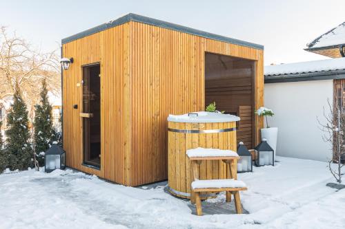 a wooden shed with a wooden barrel in the snow at Dream Holiday z Sauna i jacuzzi Lovely Krynica Zdrój in Florynka