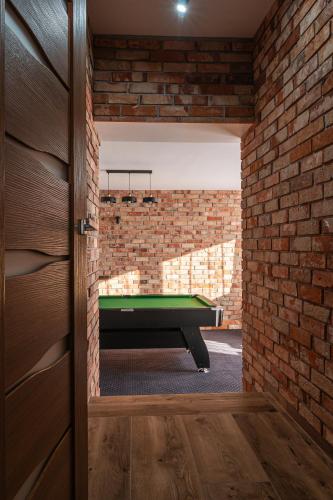 a room with a pool table in a brick wall at Dream Holiday z Sauna i jacuzzi Lovely Krynica Zdrój in Florynka