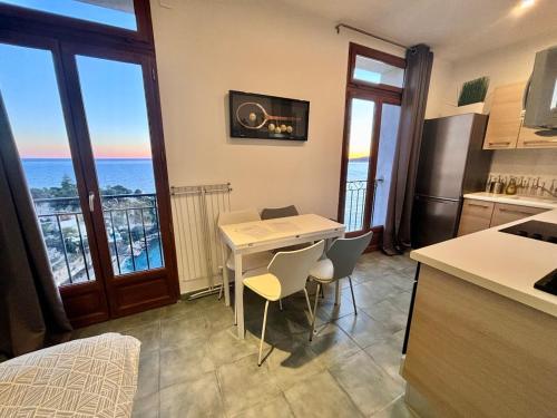 - une cuisine avec une table et des chaises offrant une vue sur l'océan dans l'établissement Terraces of Cap d 'Ail 1, à Cap d'Ail