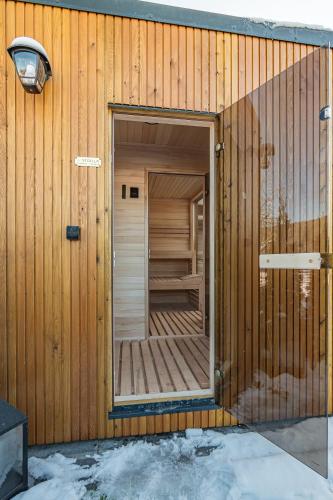 a wooden building with a door open on it at Dream Holiday z Sauna i jacuzzi Lovely Krynica Zdrój in Florynka