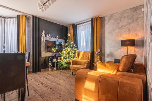 a living room with a christmas tree and a couch at Dream Holiday z Sauna i jacuzzi Lovely Krynica Zdrój in Florynka