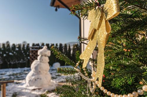 a christmas tree with a snowman in the background at Dream Holiday z Sauna i jacuzzi Lovely Krynica Zdrój in Florynka