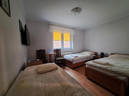 a bedroom with two beds and a window at Hotel Wiktor in Świdwin