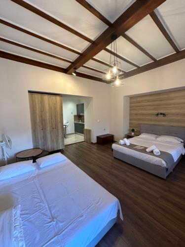two beds in a large room with wooden floors at 11 Luxury Apartments in Metsovo