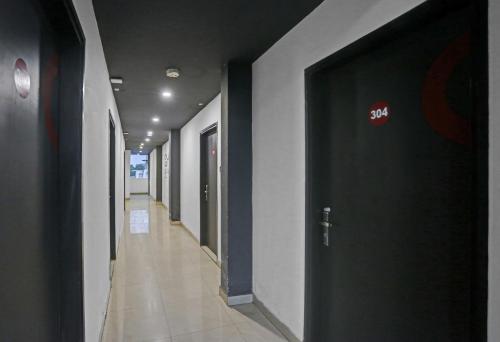 a hallway with a black door in a building at Townhouse Nangal Raya Pankha Road in New Delhi