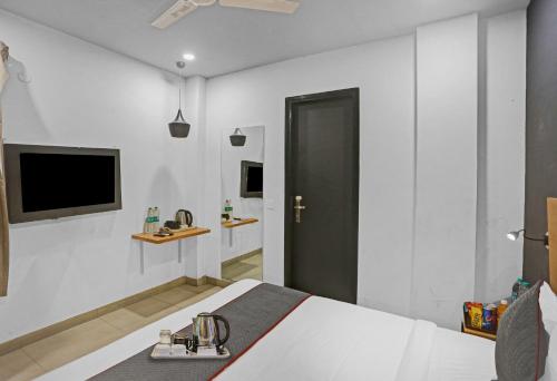a bedroom with a bed and a tv on the wall at Townhouse Nangal Raya Pankha Road in New Delhi
