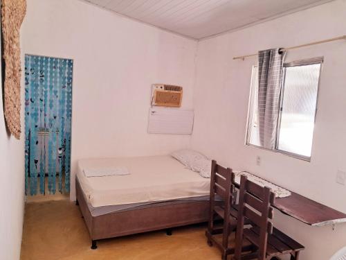 een kleine kamer met een bed en een raam bij Casinha Guiné in Morro de São Paulo